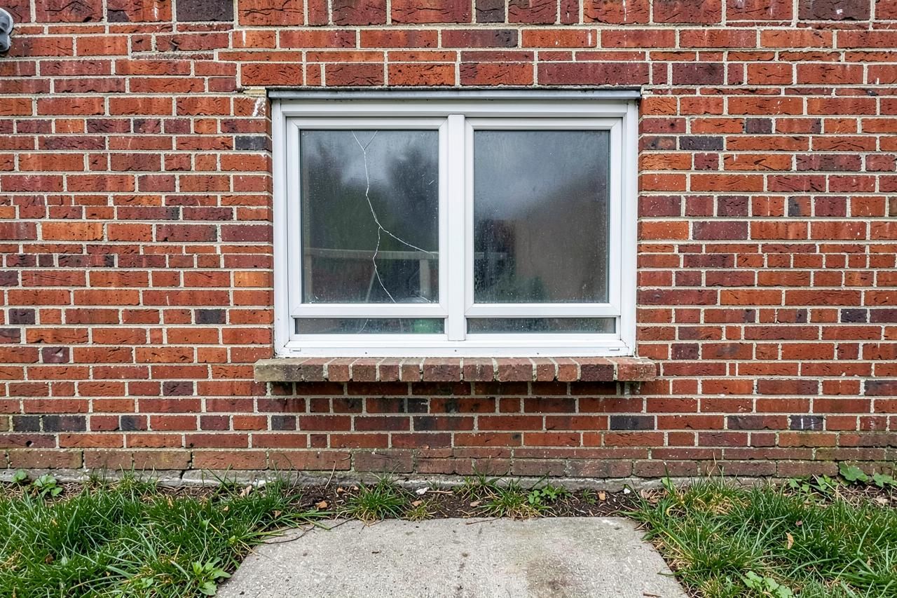Basement window with a cracked and hazy double pane unit before replacement
