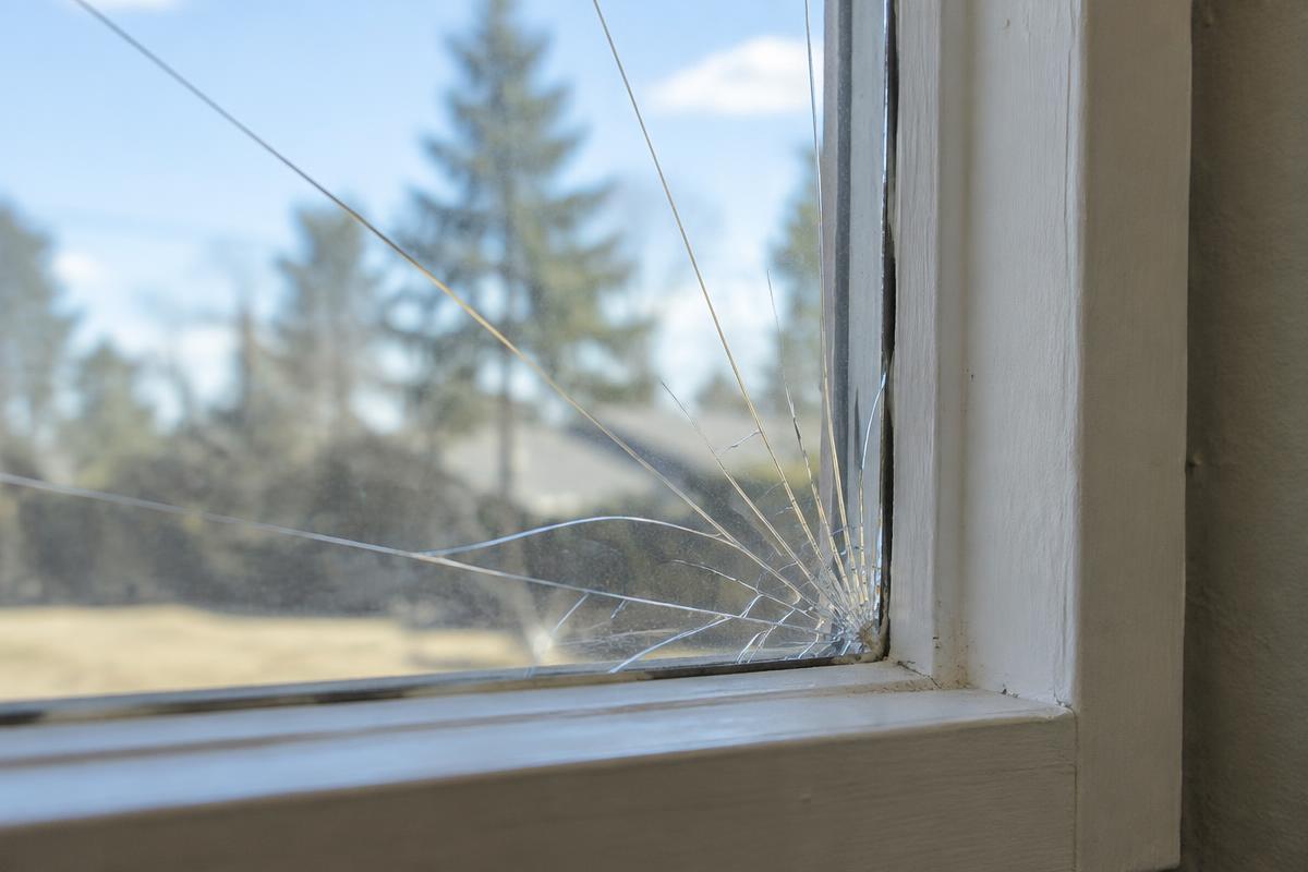 Cracked single-pane residential window before repair